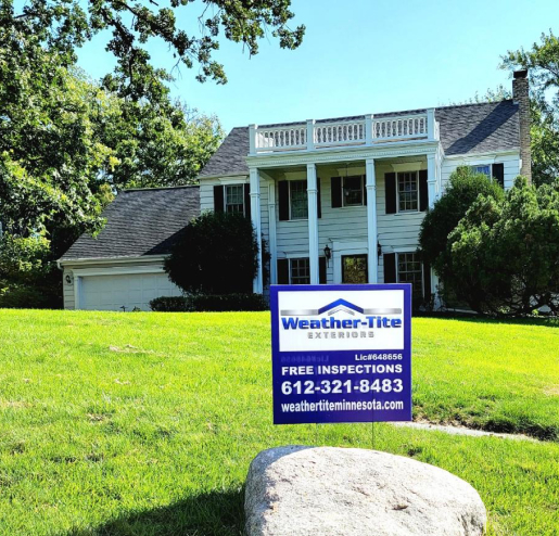 Weather-Tite Exteriors sign on the front yard of a beautiful residence